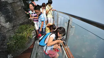 El puente, de un metro y medio de ancho, cuelga del lado más alto del acantilado de la montaña de Tianmen. Para aquellos que no sufren de vértigo, es una gran oportunidad para tomar bonitas fotos. El puente, de un metro y medio de ancho, cuelga del lado más alto del acantilado de la montaña de Tianmen. Para aquellos que no sufren de vértigo, es una gran oportunidad para tomar bonitas fotos.