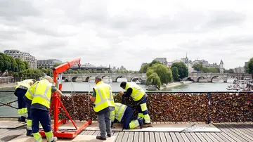 Empleados municipales retiran los "candados del amor" en París, Francia. Empleados municipales retiran los "candados del amor" en París, Francia.