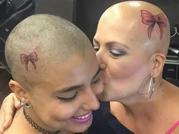 Madre e hija con el tatuaje en la cabeza Madre e hija con el tatuaje en la cabeza