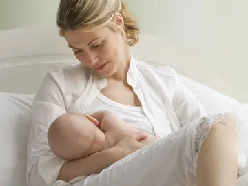 Una madre amamantando a su bebé Una madre amamantando a su bebé