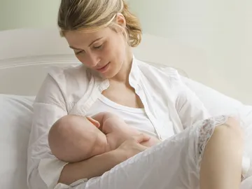 Una madre amamantando a su bebé Una madre amamantando a su bebé