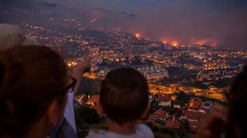Un grupo de personas observa un incendio forestal en Funchal