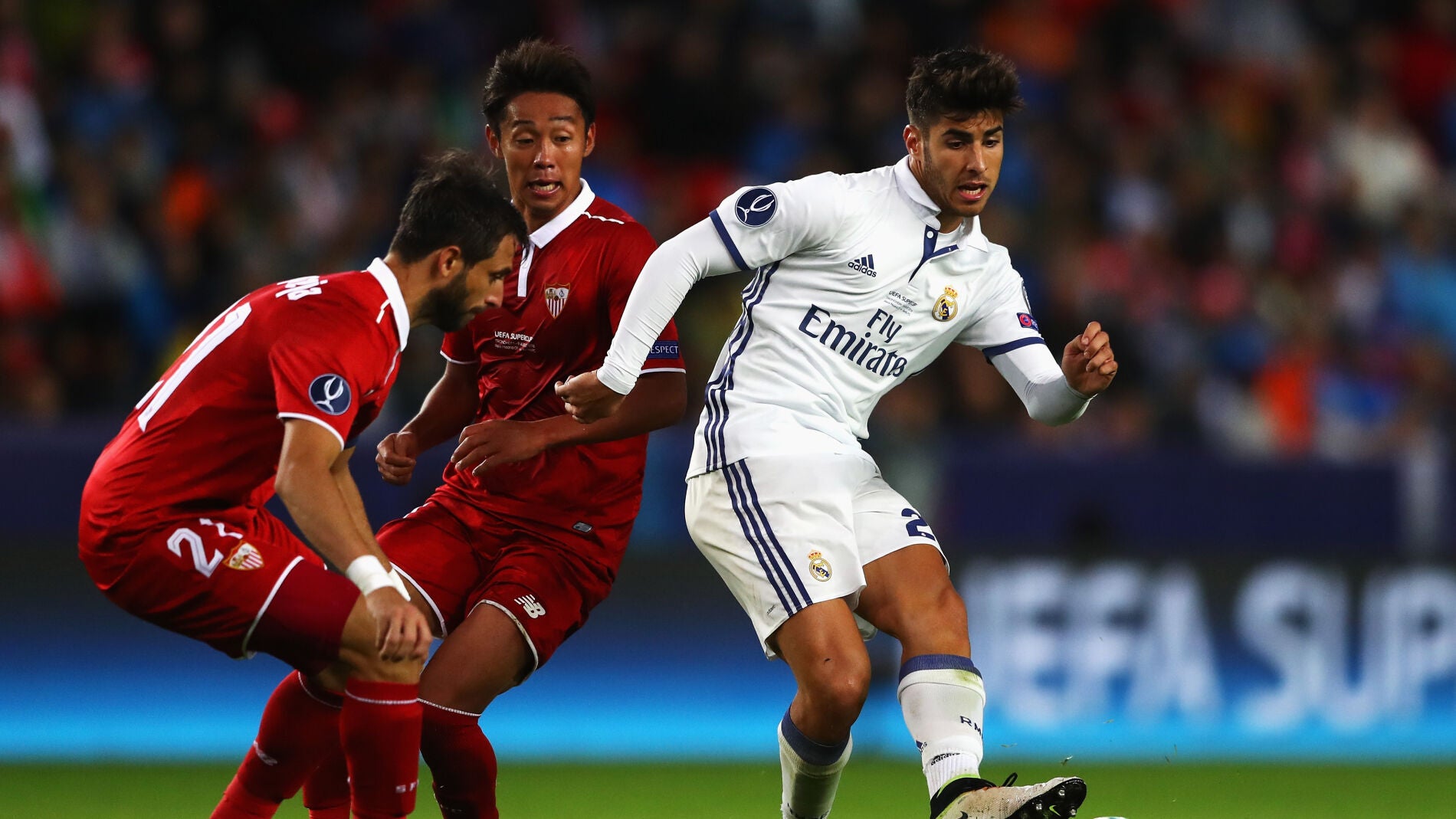 Marco Asensio pasa el bal&oacute;n ante el Sevilla