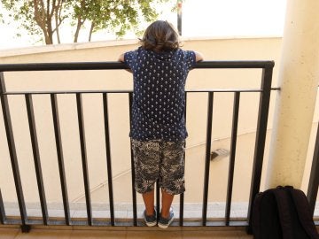 Un niño mira por un balcón