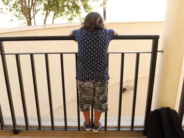 Un niño mira por un balcón Un niño mira por un balcón
