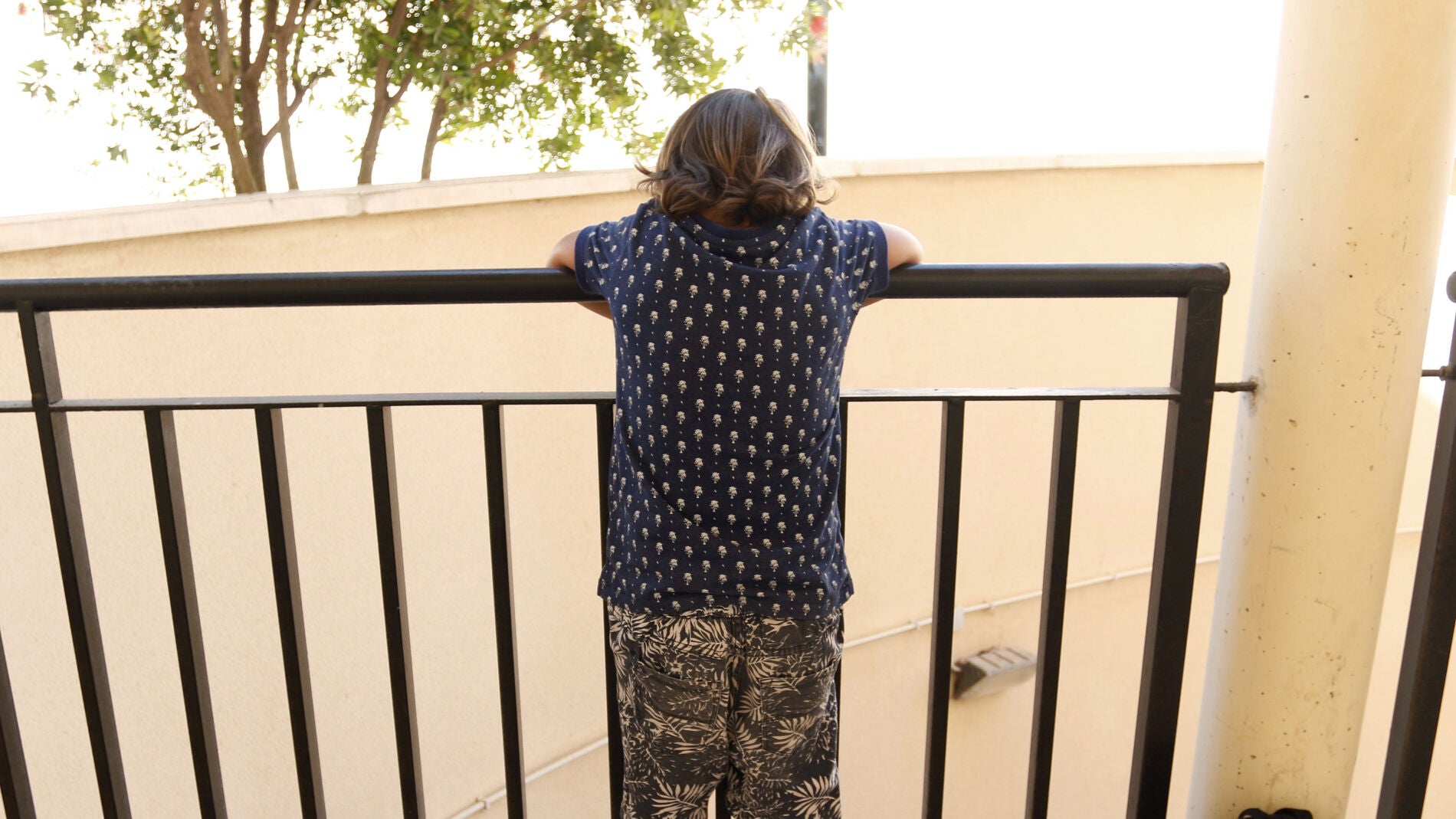 Un ni&ntilde;o mira por un balc&oacute;n