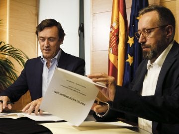 Rafael Hernando y Juan Carlos Girauta firmando el acuerdo en el Congreso.