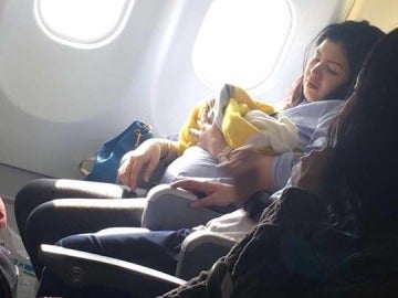 Mamá junto a su bebé recién nacido en en avión