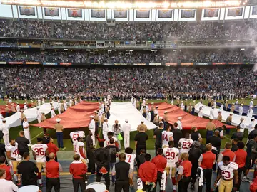 Colin Kaepernick, en la parte inferior de la fotografía (lleva el dorsal 7), de rodillas mientras suena el himno de Estados Unidos Colin Kaepernick, en la parte inferior de la fotografía (lleva el dorsal 7), de rodillas mientras suena el himno de Estados Unidos
