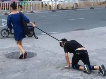 Una mujer china pasea a su novio con una correa como si fuera un perro Una mujer china pasea a su novio con una correa como si fuera un perro