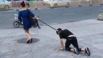 Una mujer china pasea a su novio con una correa como si fuera un perro 