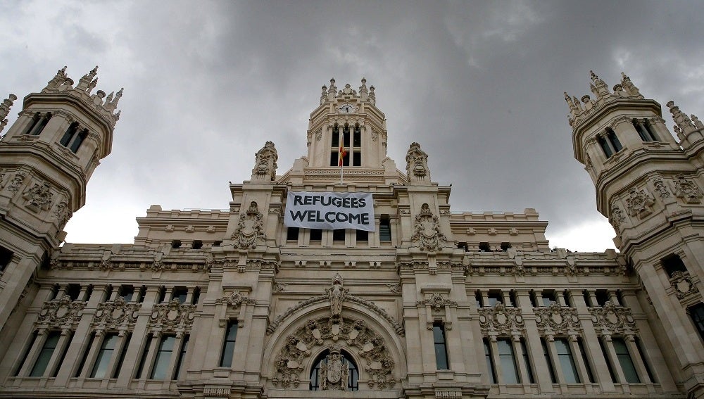 Detalle de una pancarta con la leyenda "Refugees Welcome" -"Refugiados, bienvenidos", colocada en la fachada del Palacio de Cibeles