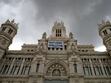 Detalle de una pancarta con la leyenda "Refugees Welcome" -"Refugiados, bienvenidos", colocada en la fachada del Palacio de Cibeles Detalle de una pancarta con la leyenda "Refugees Welcome" -"Refugiados, bienvenidos", colocada en la fachada del Palacio de Cibeles