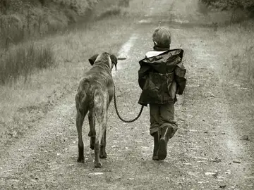 Niño paseando por un perro Niño paseando por un perro