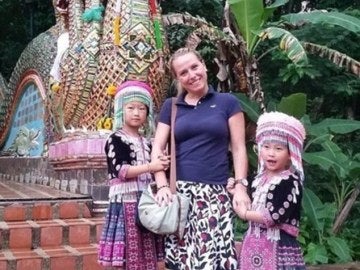 La mujer posando con las dos niñas caracterizadas en Tailandia