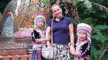 La mujer posando con las dos niñas caracterizadas en Tailandia