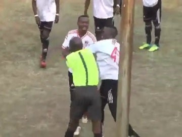 Un árbitro y un jugador pegándose en Zimbabue.