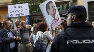  Dos simpatizantes muestran sendas pancartas a las puertas de la sede del PSOE