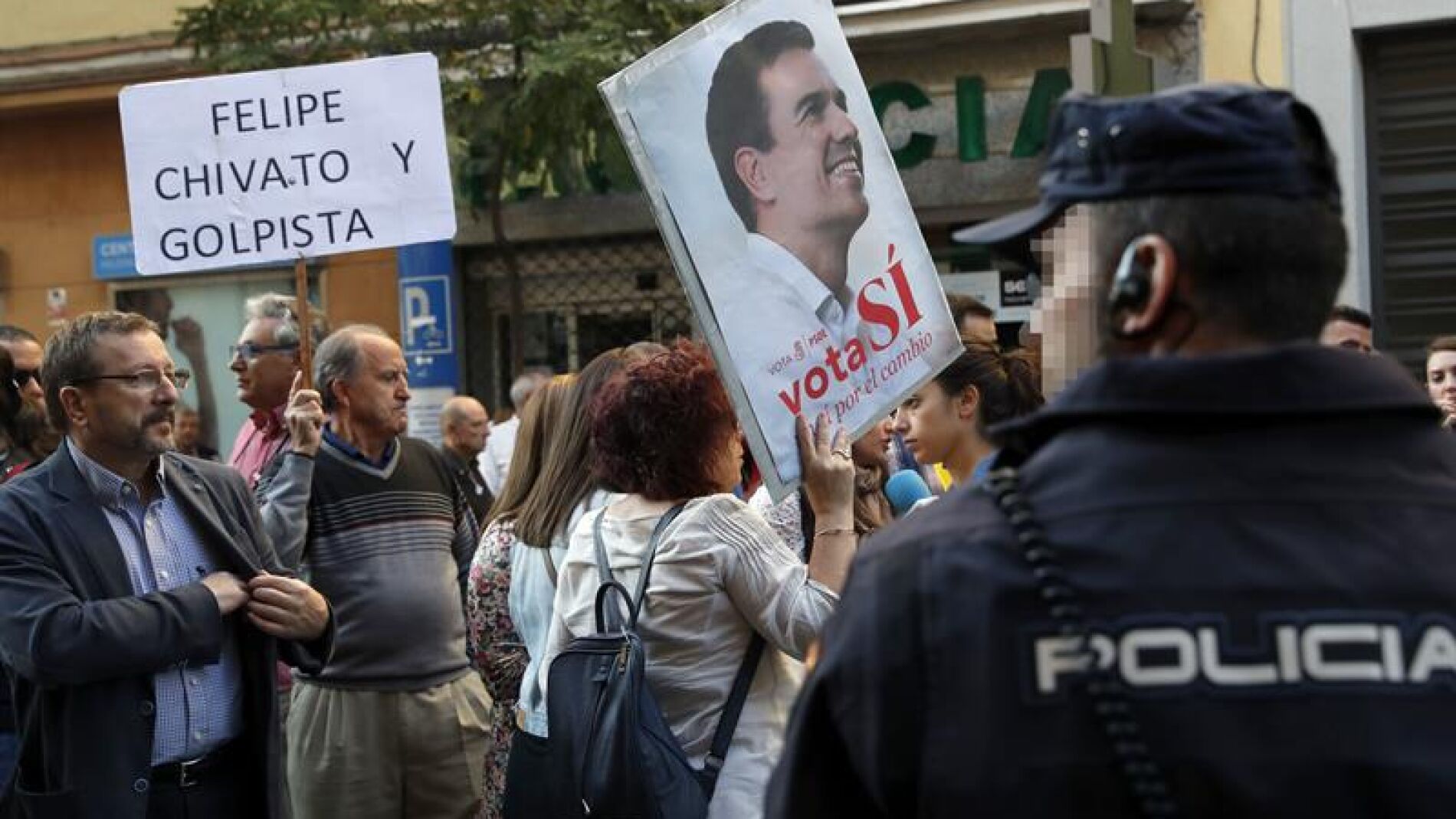  Dos simpatizantes muestran sendas pancartas a las puertas de la sede del PSOE