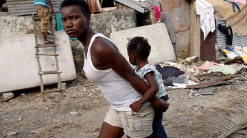 Una mujer con su hija camina en Haití entre los escombros provocados por Matthew