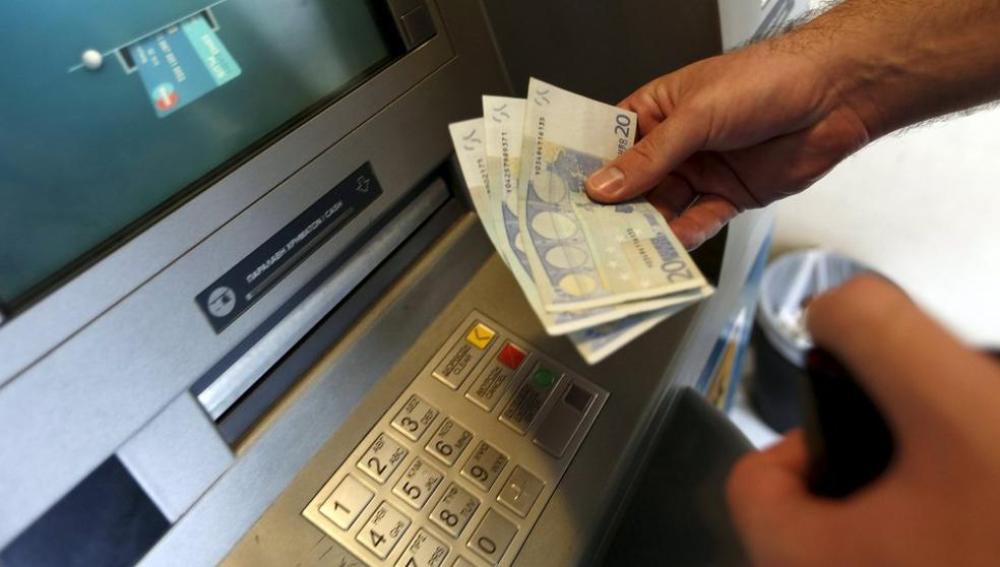 Una mujer saca dinero de un banco
