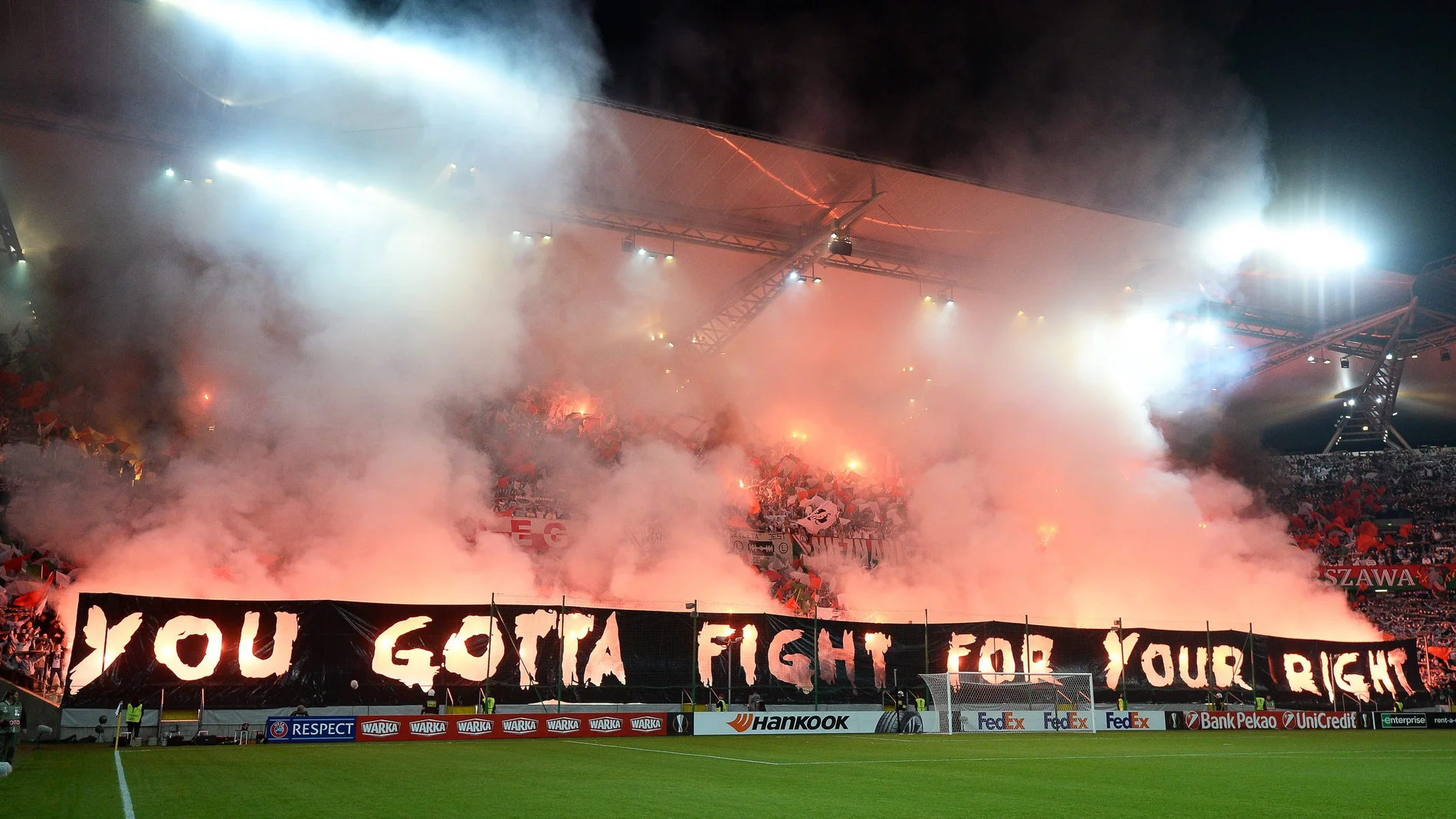 Aficionados del Legia encienden bengalas en su estadio en Varsovia