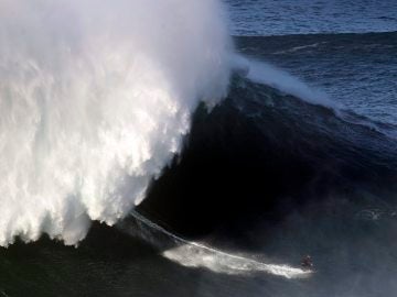 Un surfista desciende una ola en Nazaré