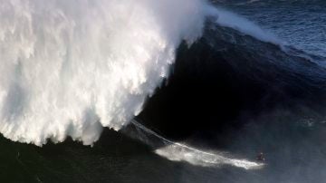 Un surfista desciende una ola en Nazaré