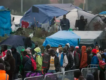 Varios migrantes esperan para su evacuación en el centro de recepción de corta estancia en el campamento conocido como "La Jungla" durante su desmantelamiento en Calais Varios migrantes esperan para su evacuación en el centro de recepción de corta estancia en el campamento conocido como "La Jungla" durante su desmantelamiento en Calais