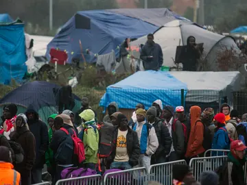 Varios migrantes esperan para su evacuación en el centro de recepción de corta estancia en el campamento conocido como "La Jungla" durante su desmantelamiento en Calais Varios migrantes esperan para su evacuación en el centro de recepción de corta estancia en el campamento conocido como "La Jungla" durante su desmantelamiento en Calais