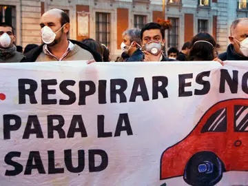 La gente usa máscaras y sostienen una pancarta durante un flashmob para marcar el problema de la contaminación en el centro de Madrid La gente usa máscaras y sostienen una pancarta durante un flashmob para marcar el problema de la contaminación en el centro de Madrid