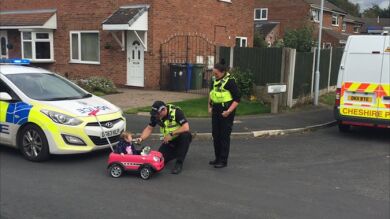 La adorable foto en la que se ve a unos agentes británicos bromean con una niña que va en un coche de juguete