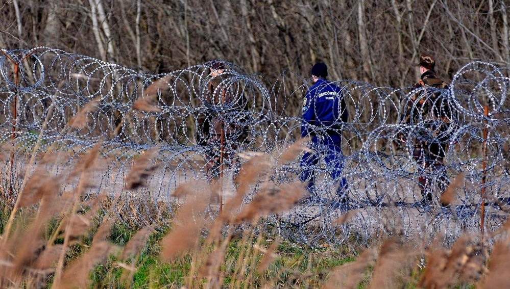 Policías y soldados húngaros patrullan junto a la valla temporal que separa la frontera entre Serbia y Hungría