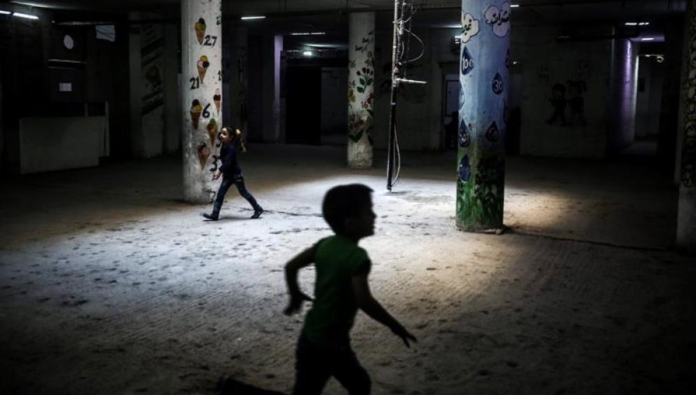 Niños sirios corren por los pasillos de una escuela 
