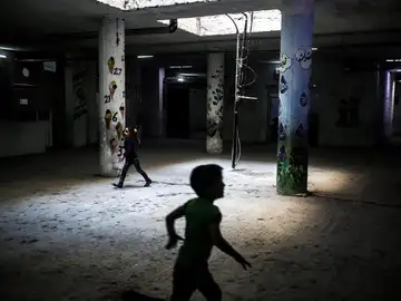 Niños sirios corren por los pasillos de una escuela Niños sirios corren por los pasillos de una escuela
