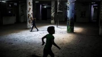 Niños sirios corren por los pasillos de una escuela 