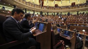 Pedro Sánchez mirando su móvil en la segunda  jornada del debate de investidura