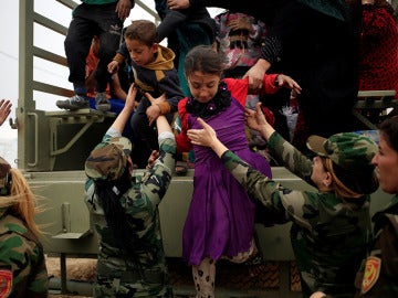 Niños bajando de un camión militar
