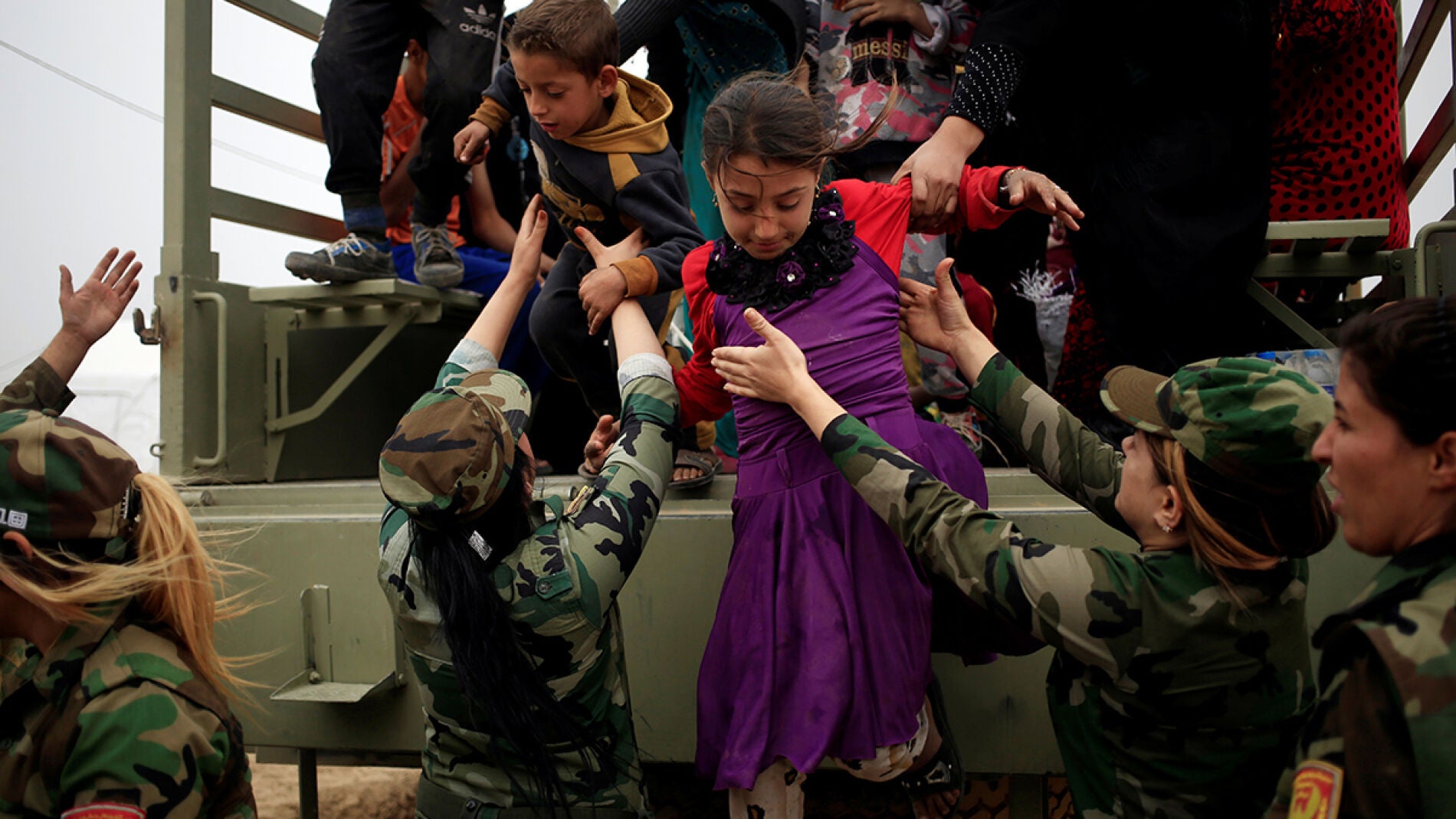Ni&ntilde;os bajando de un cami&oacute;n militar