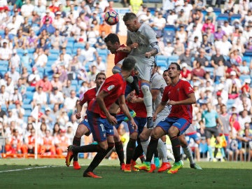 Defensas del Osasuna luchan por un balón aéreo con Sergio Ramos