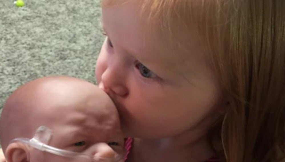 Una niña con el muñeco que imita a su hermano enfermo
