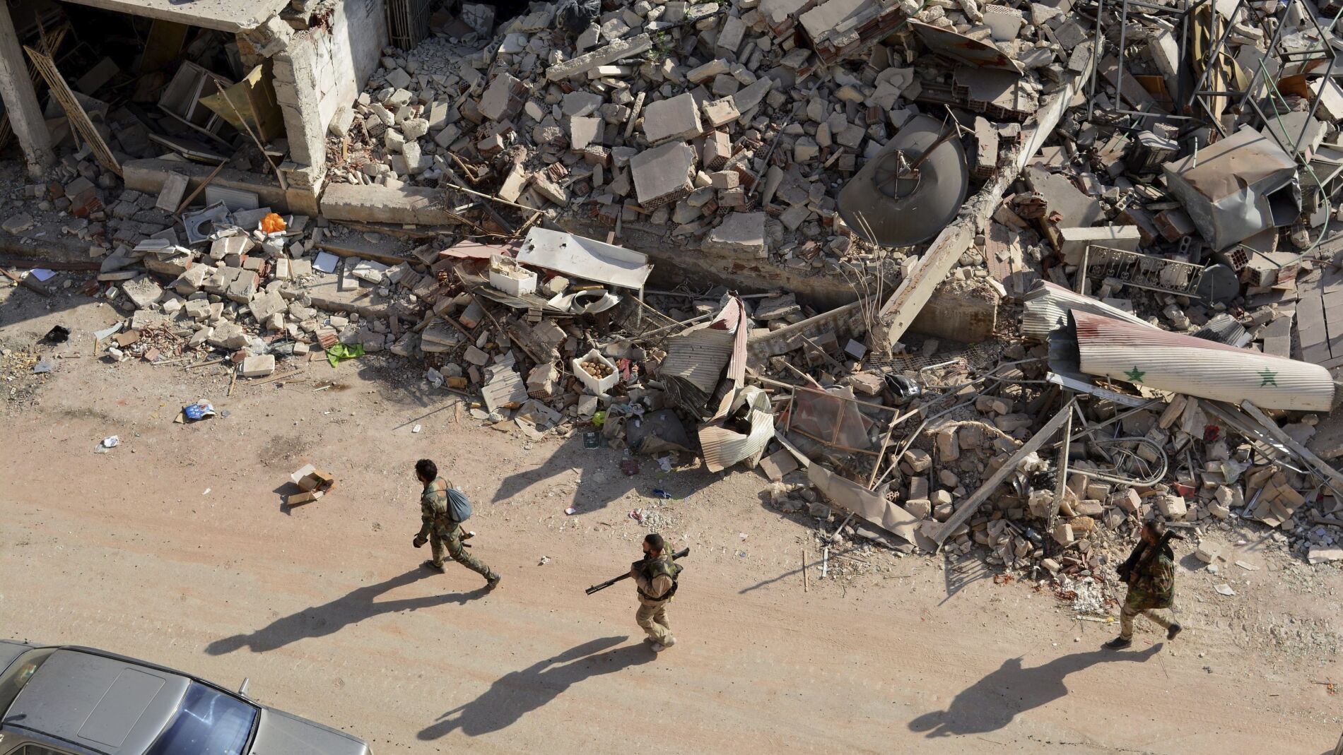 Soldados sirios caminan entre los escombros en el oeste de Alepo