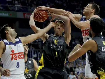 Fran Vázquez intenta atrapar un rebote ante Felipe Reyes y Maciulis Fran Vázquez intenta atrapar un rebote ante Felipe Reyes y Maciulis