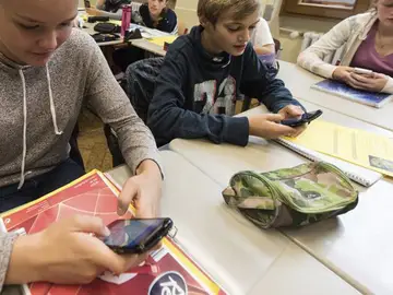 Unos alumnos utilizan el smartphone en clase Unos alumnos utilizan el smartphone en clase