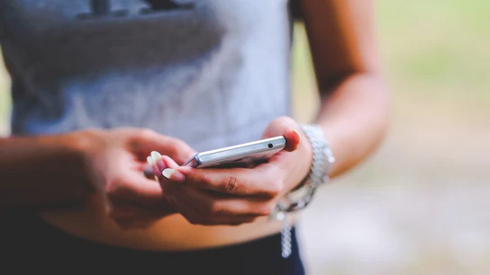 Una joven con un teléfono móvil Una mujer con un teléfono móvil