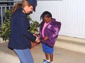 La pequeña Oumoh con una policía La pequeña Oumoh con una policía