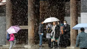 Turistas caminan bajo la nieve de Tokio Turistas caminan bajo la nieve de Tokio
