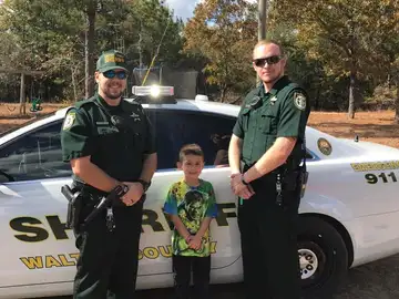 Niño y dos agentes de sheriff Niño y dos agentes de sheriff