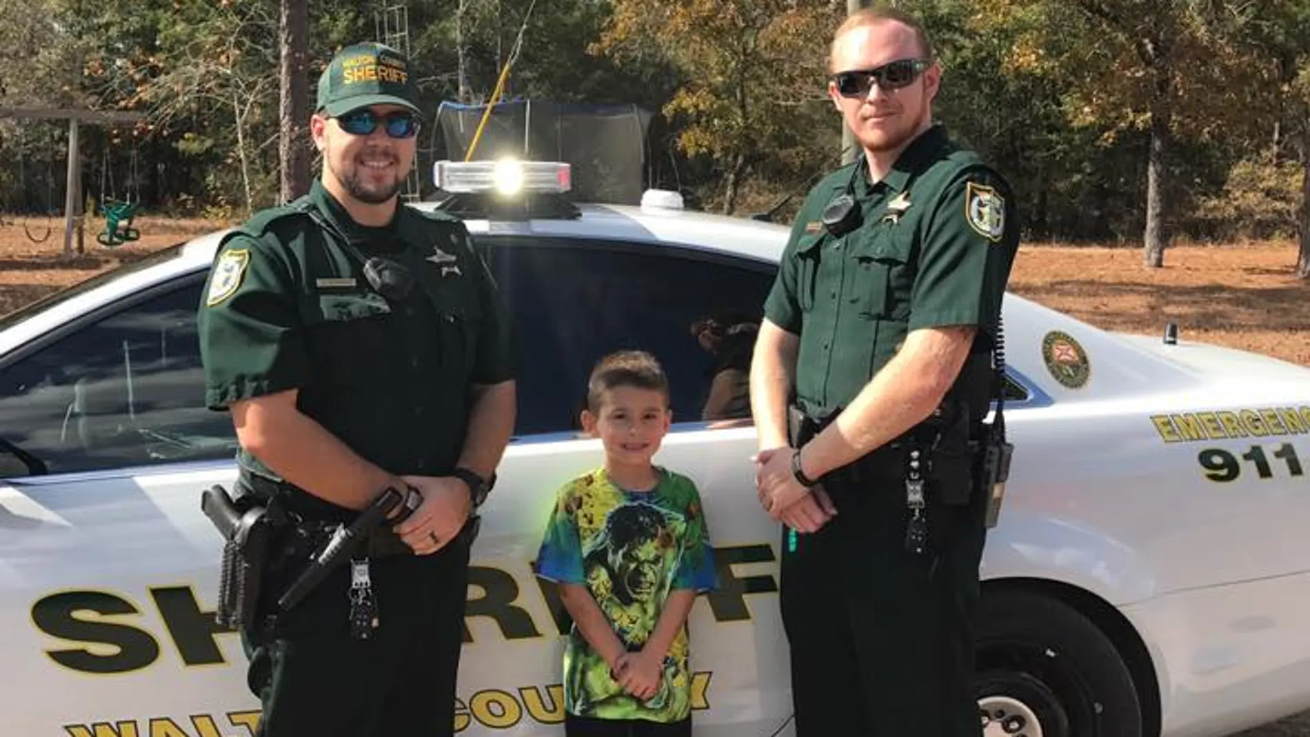 Niño y dos agentes de sheriff Niño y dos agentes de sheriff