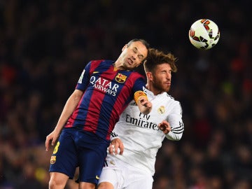 Iniesta y Sergio Ramos atacan un balón dividido